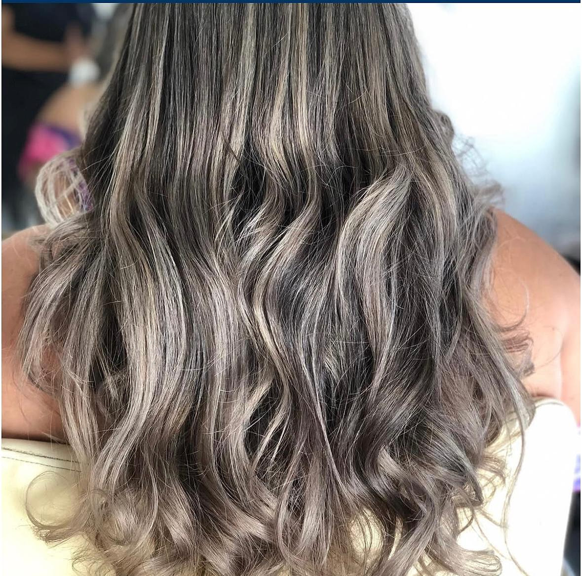 Cabello largo con mechas plateadas y ceniza difuminadas sobre base castaña, en ondas suaves.
